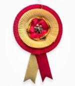 Two-layer ribbon badge in red and golden color with central decorative flower
