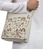 Close-up of Warli art canvas shoulder bag on a model.