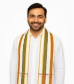 White cotton gamcha with orange, red, and green border worn by smiling Indian man