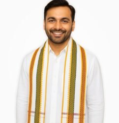 White cotton gamcha with orange, red, and green border worn by smiling Indian man