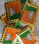 BJP metal badge party symbol saffron green gold border close up view
