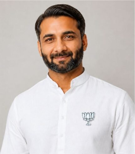 Smiling Indian man wearing BJP White Kamal Badge on white kurta