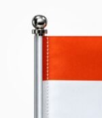 Close-up of the table flag’s ball-shaped pole top, white mounting sleeve and stitched satin flag edge